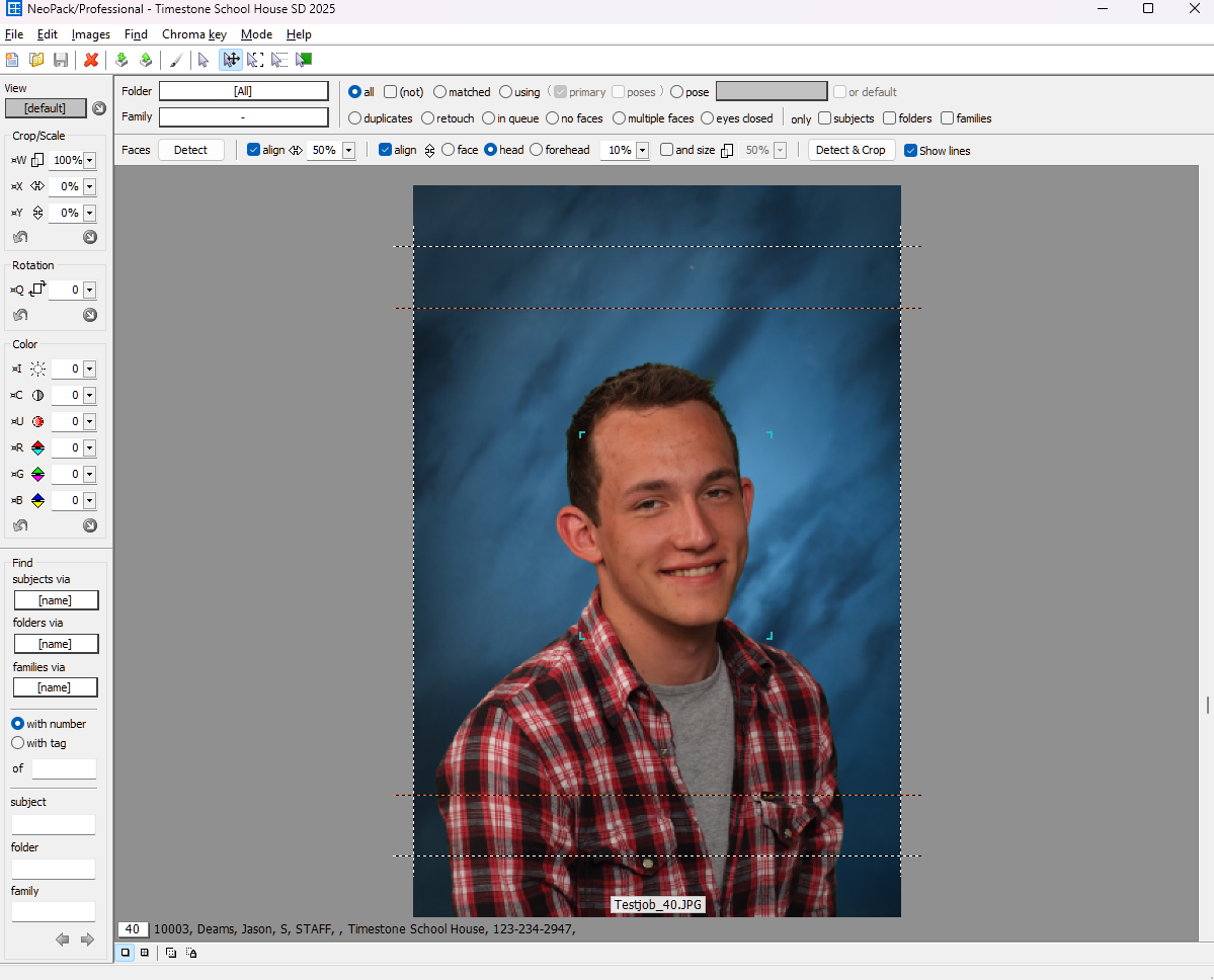 A young man smiling in a professional photo with a blue background.