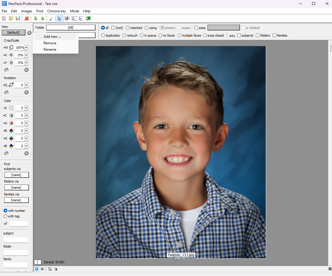 A smiling boy with light brown hair wearing a checkered shirt poses for a photo.