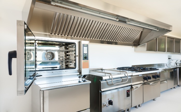 A commercial kitchen with stainless steel appliances Description automatically generated