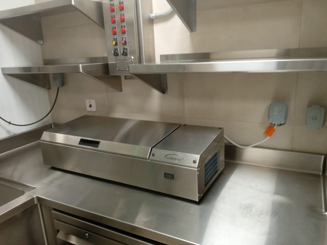A stainless steel machine on a counter Description automatically generated