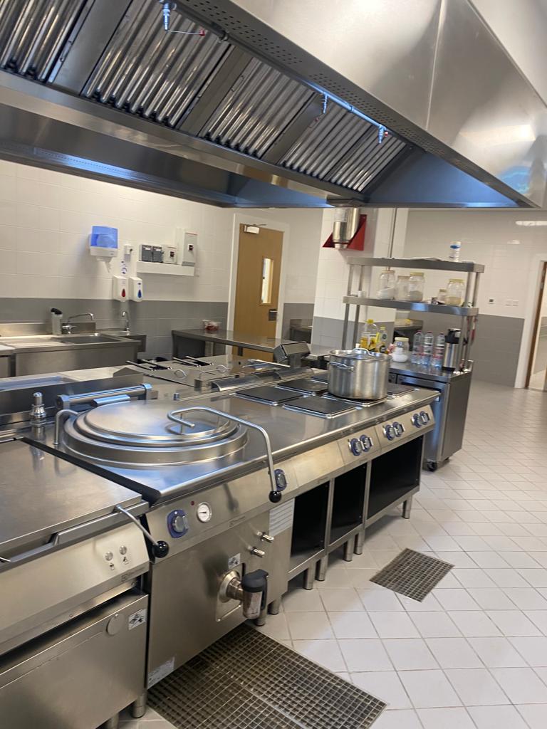 A large kitchen with stainless steel appliances Description automatically generated
