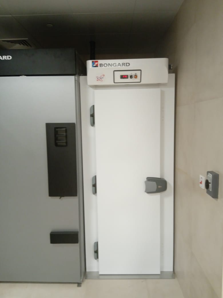 A white door with a button on the top Description automatically generated