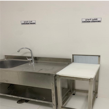 A sink and stool in a kitchen Description automatically generated