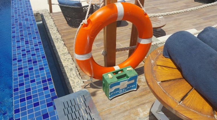 A life preserver next to a pool AI-generated content may be incorrect.
